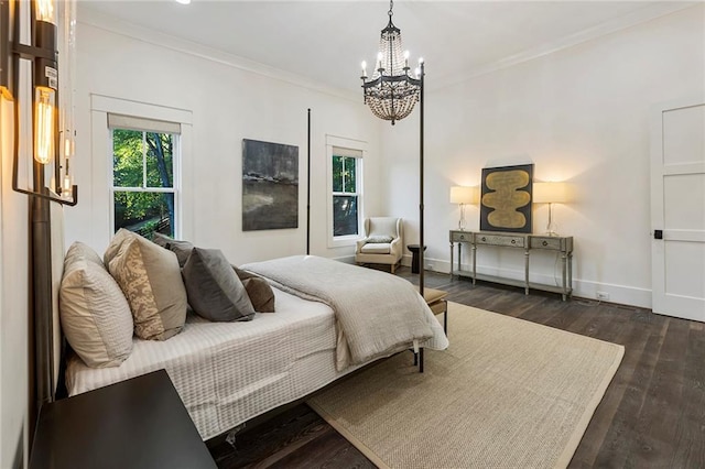 bedroom featuring crown molding, dark hardwood / wood-style floors, and an inviting chandelier