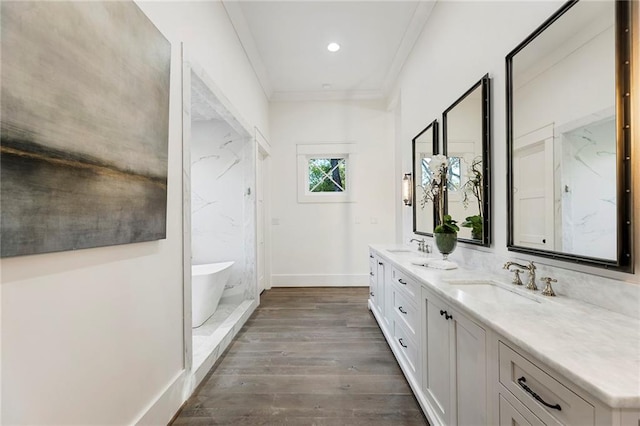 bathroom featuring vanity, a tub to relax in, hardwood / wood-style flooring, and crown molding