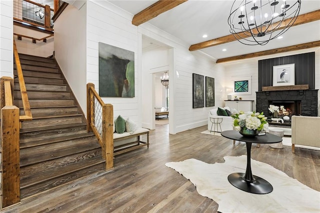 entryway with a stone fireplace, hardwood / wood-style floors, and beamed ceiling