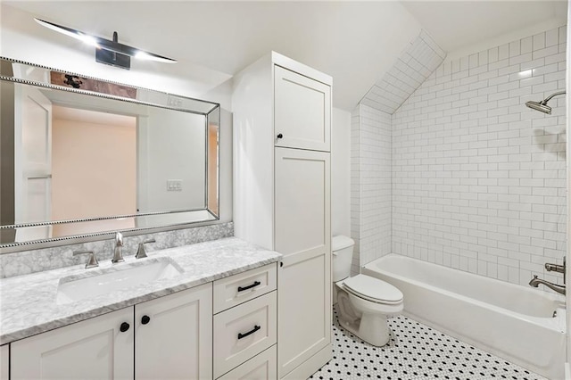 full bathroom featuring vaulted ceiling, toilet, vanity, tiled shower / bath combo, and tile patterned floors