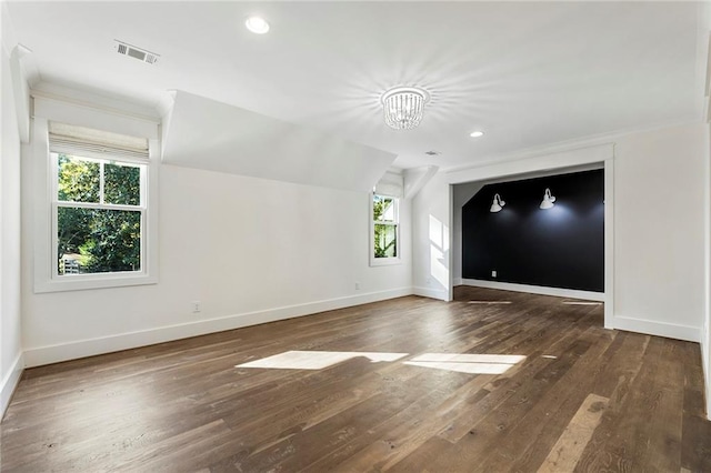 interior space featuring an inviting chandelier, ornamental molding, a healthy amount of sunlight, and dark hardwood / wood-style flooring