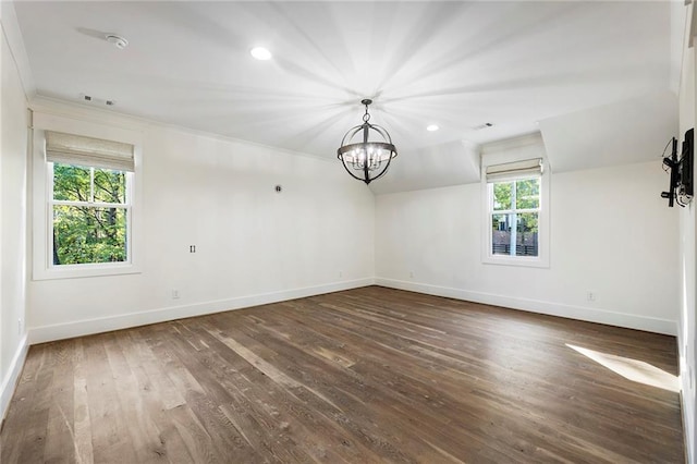 unfurnished room featuring a wealth of natural light, crown molding, a notable chandelier, and dark hardwood / wood-style flooring