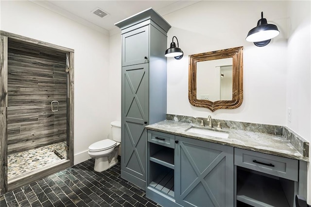 bathroom with a shower with door, vanity, ornamental molding, and toilet