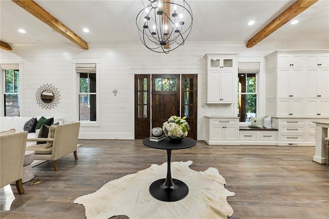 foyer entrance featuring beamed ceiling, dark hardwood / wood-style floors, and a healthy amount of sunlight