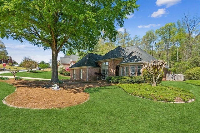 ranch-style house featuring brick siding and a front lawn