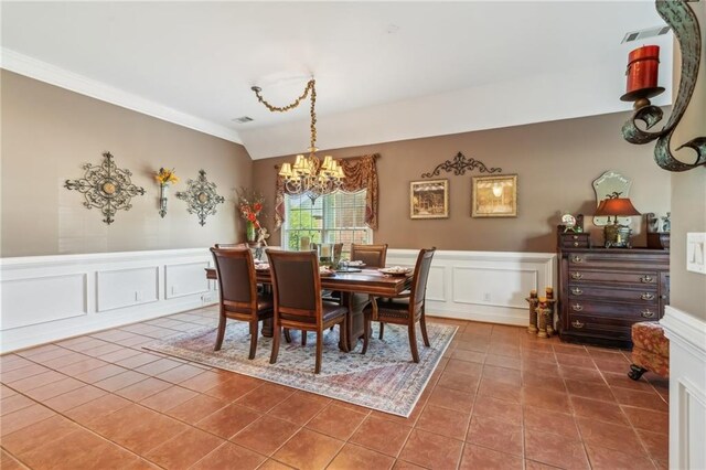 dining room featuring visible vents, wainscoting, tile patterned floors, an inviting chandelier, and a decorative wall