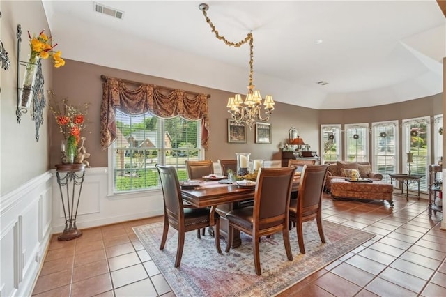 dining room with light tile patterned floors, visible vents, an inviting chandelier, and a wainscoted wall