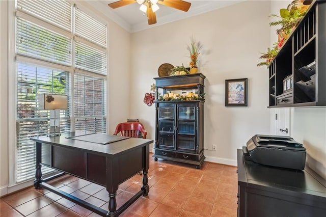 office area with crown molding, a ceiling fan, baseboards, and light tile patterned flooring