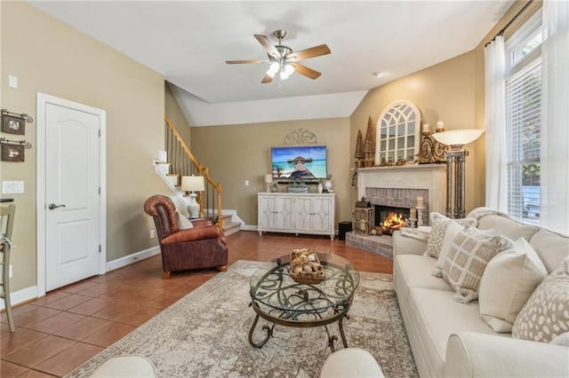 living room featuring stairs, tile patterned floors, ceiling fan, and a fireplace