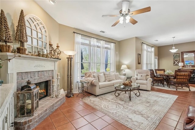living room with ceiling fan, visible vents, tile patterned flooring, and a fireplace