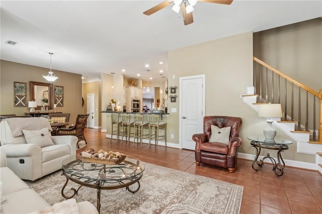 tiled living room featuring a ceiling fan, visible vents, stairs, baseboards, and recessed lighting