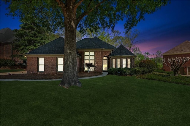 view of front of home with brick siding and a front lawn