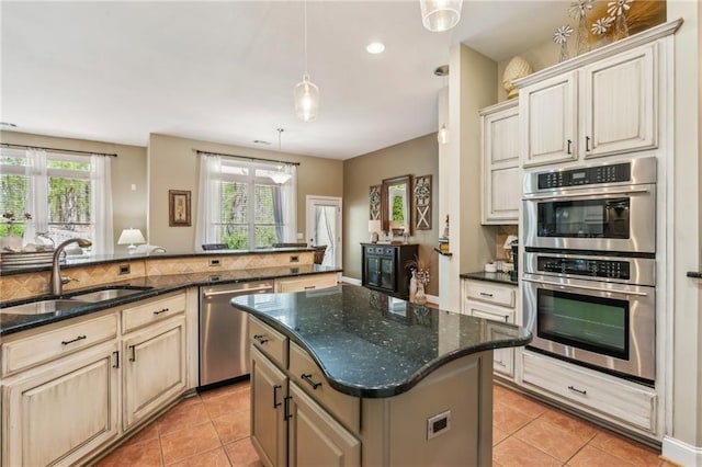 kitchen featuring a sink, light tile patterned floors, a kitchen island, and stainless steel appliances