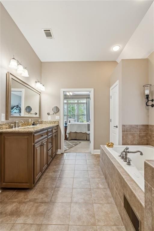 full bathroom with double vanity, tiled tub, visible vents, tile patterned flooring, and a sink