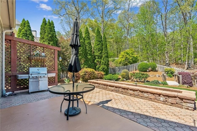view of patio with grilling area and fence
