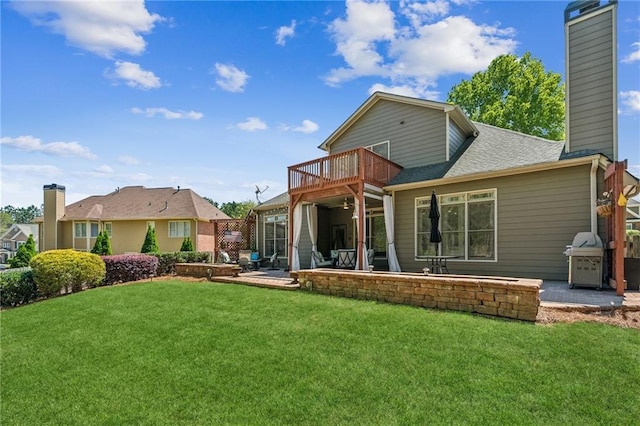 rear view of house featuring a lawn, a patio, a chimney, and a balcony