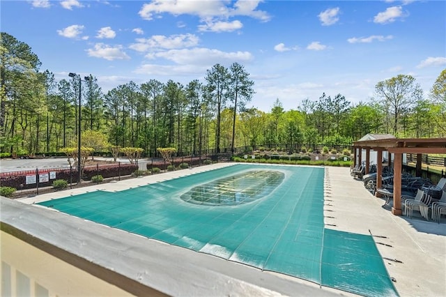 view of swimming pool featuring fence