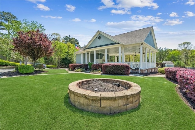 back of house featuring a lawn and a fire pit