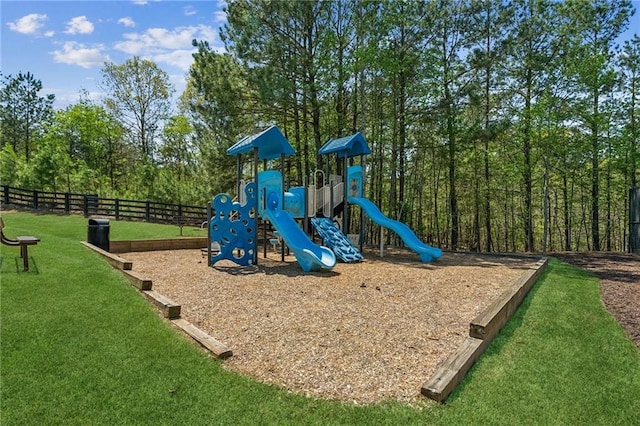community playground featuring a lawn and fence