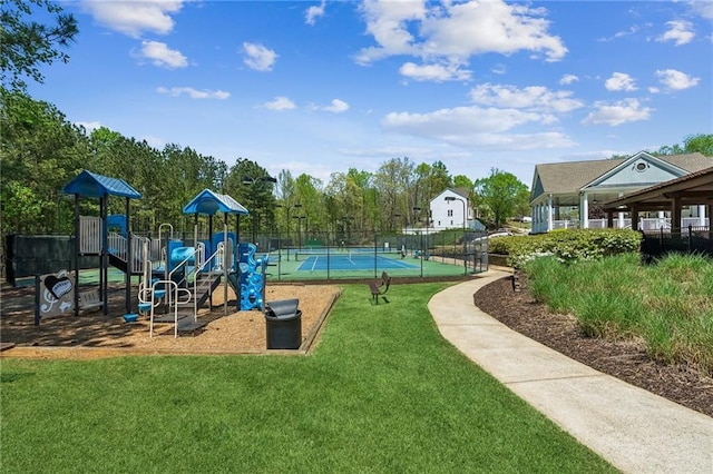 community jungle gym featuring a yard, a tennis court, and fence