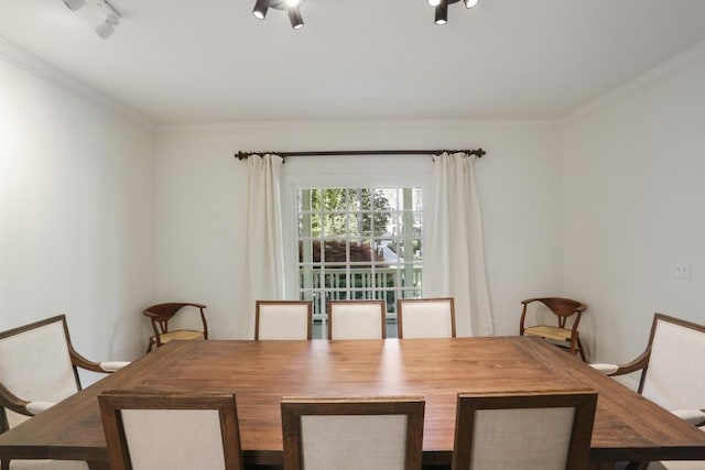 dining space featuring rail lighting, baseboards, and ornamental molding