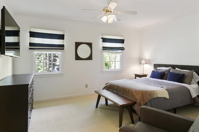 bedroom featuring light carpet, a ceiling fan, crown molding, and baseboards