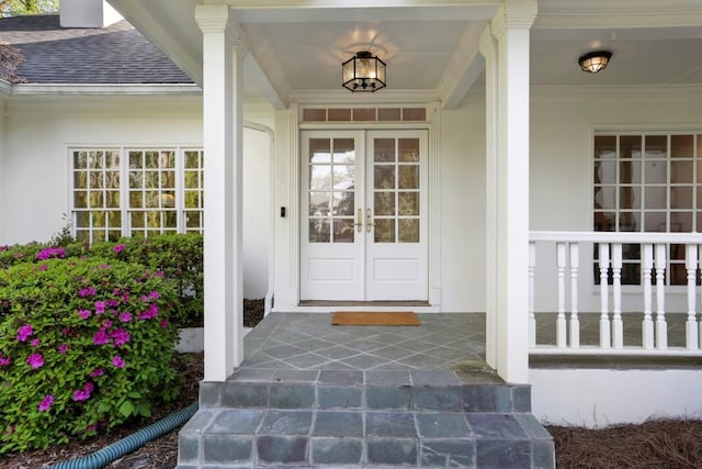 property entrance featuring a porch, stucco siding, french doors, and a shingled roof