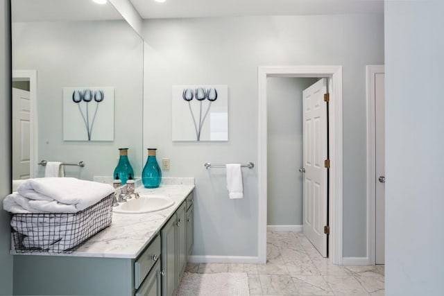 bathroom with vanity, baseboards, and marble finish floor