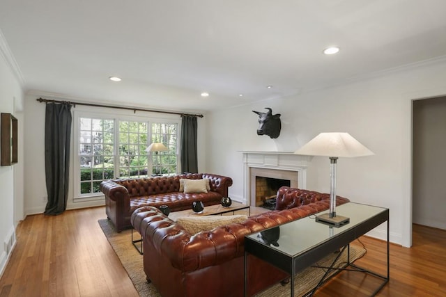 living area with recessed lighting, wood finished floors, and crown molding