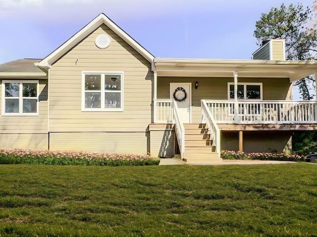 ranch-style home featuring a chimney, a porch, and a front lawn