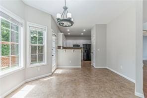 unfurnished living room with a chandelier