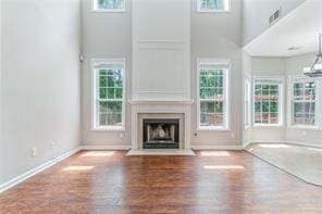 unfurnished living room with a high ceiling and a chandelier