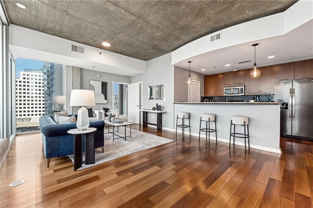 living area featuring a view of city, visible vents, dark wood finished floors, and baseboards