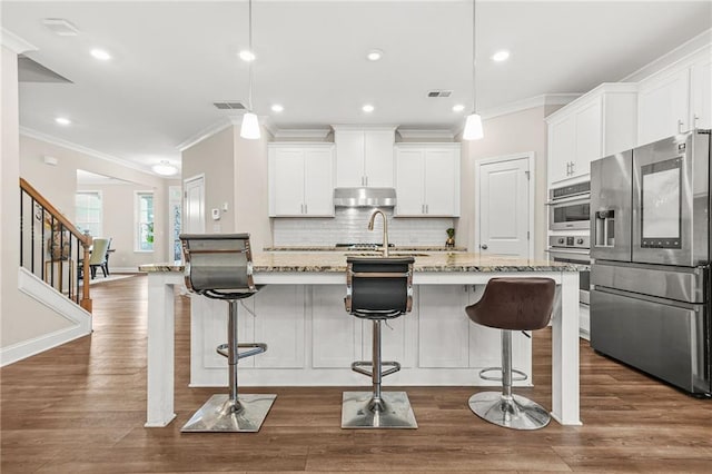 4110 Morgan Elizabeth Way, Cumming, GA 30041 - kitchen featuring appliances with stainless steel finishes, crown molding, decorative backsplash, white cabinetry, and under cabinet range hood