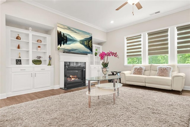 4110 Morgan Elizabeth Way, Cumming, GA 30041 - living room featuring wood finished floors, crown molding, a glass covered fireplace, ceiling fan, and recessed lighting