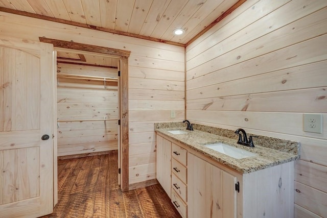 bathroom with wood ceiling, double vanity, wood walls, and a sink