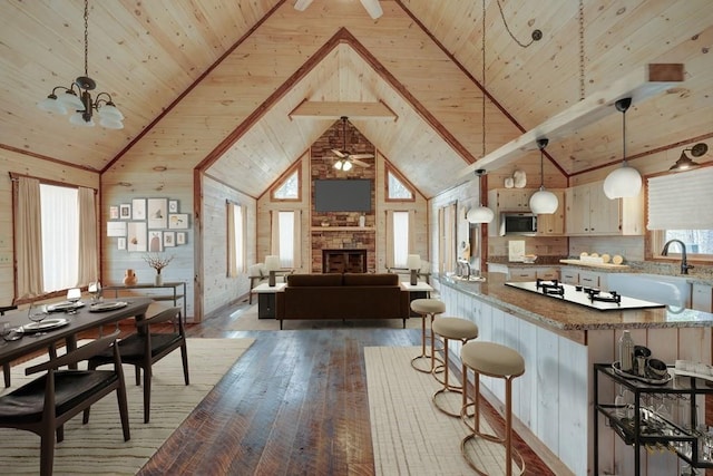 kitchen featuring wood ceiling, stainless steel microwave, a wealth of natural light, and light wood-style floors