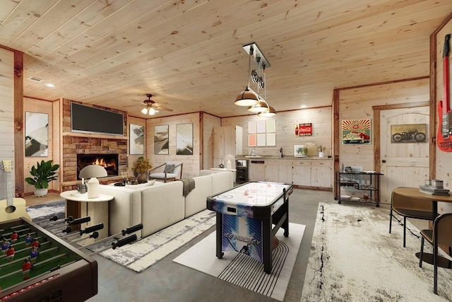 game room with a fireplace, concrete floors, a ceiling fan, wooden ceiling, and wooden walls
