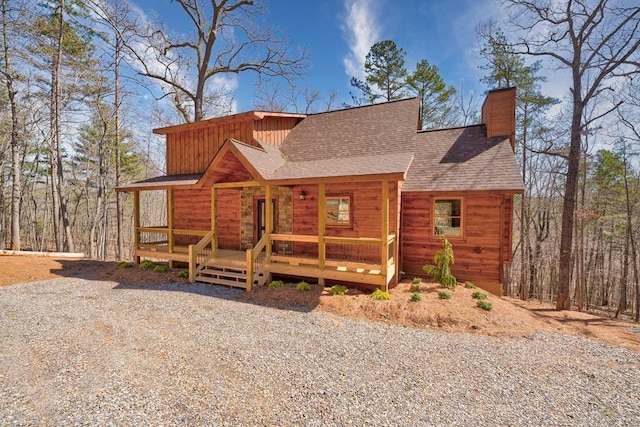 view of front of home with board and batten siding, a chimney, and a shingled roof