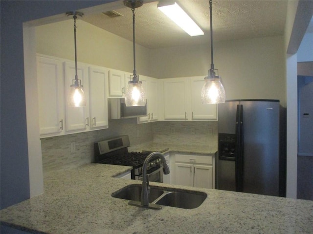 kitchen featuring appliances with stainless steel finishes, sink, white cabinetry, and pendant lighting