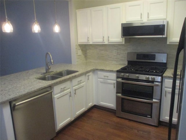 kitchen featuring pendant lighting, stainless steel appliances, and white cabinetry