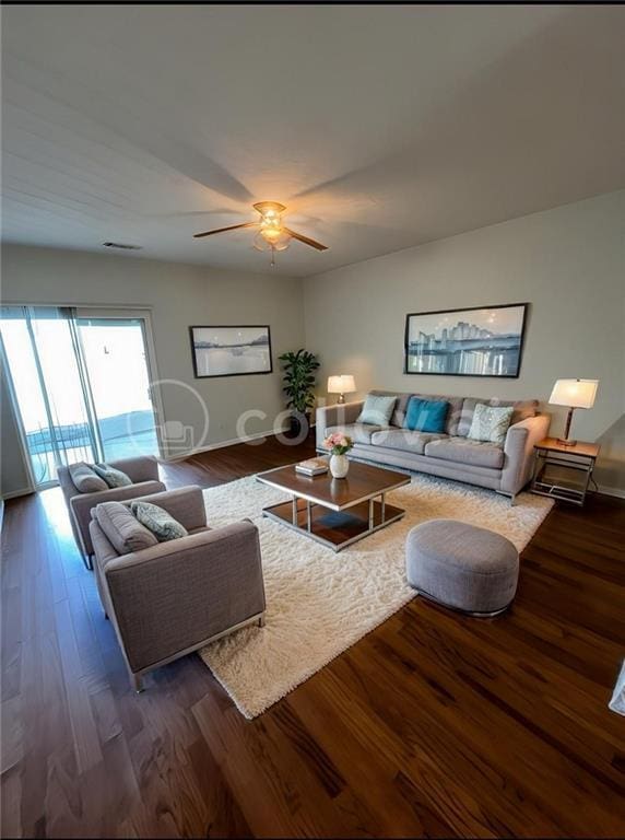 living room featuring ceiling fan and dark hardwood / wood-style flooring