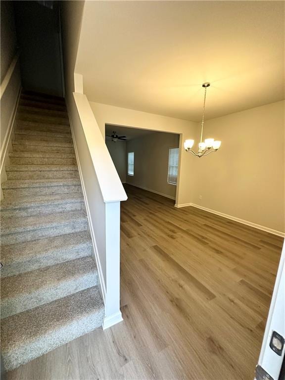 836 Courthouse Park Dr, Temple, GA 30179 - stairway featuring wood finished floors, a chandelier, and baseboards