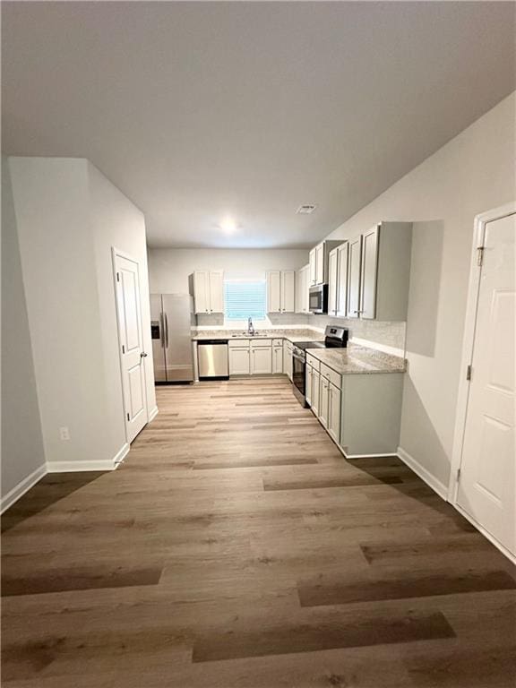 836 Courthouse Park Dr, Temple, GA 30179 - kitchen featuring stainless steel appliances, light countertops, baseboards, and light wood-style flooring