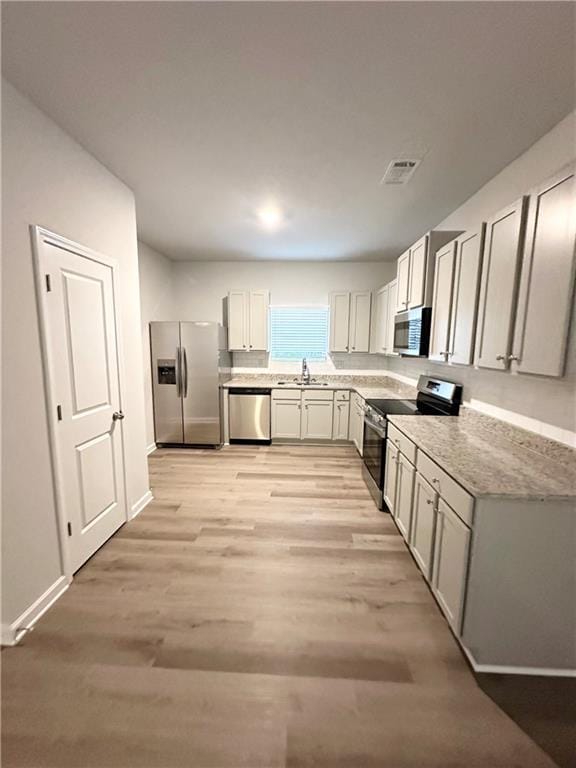 836 Courthouse Park Dr, Temple, GA 30179 - kitchen featuring appliances with stainless steel finishes, a sink, light wood-type flooring, and baseboards