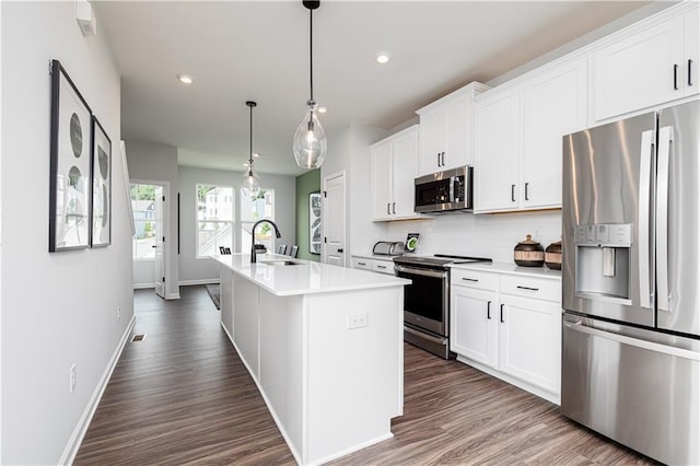 2682 Brookview Ln NW, Atlanta, GA 30318 - kitchen featuring stainless steel appliances, decorative backsplash, dark wood finished floors, a kitchen island with sink, and light countertops