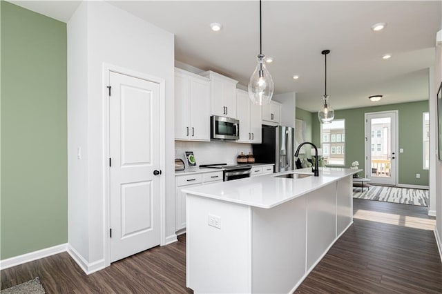 2682 Brookview Ln NW, Atlanta, GA 30318 - kitchen with appliances with stainless steel finishes, an island with sink, dark wood-type flooring, white cabinetry, and recessed lighting