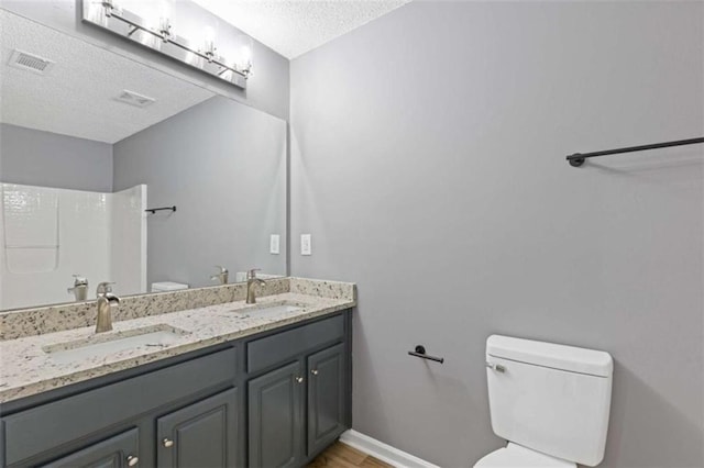 2183 Miranda Dr, Morrow, GA 30260 - bathroom with a textured ceiling, double vanity, a shower, and wood finished floors