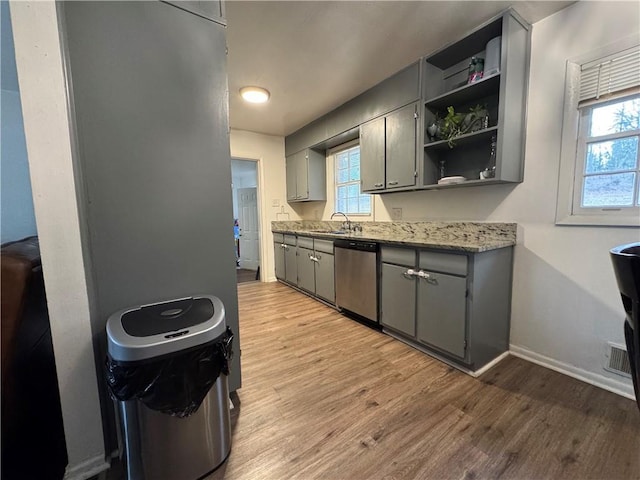 kitchen featuring open shelves, light wood-style flooring, gray cabinets, and stainless steel dishwasher