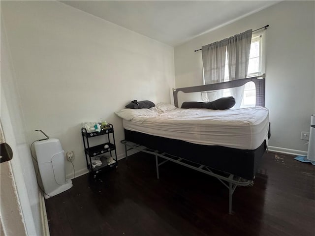 bedroom featuring baseboards and wood finished floors